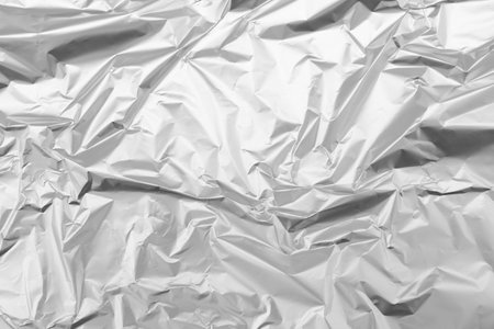 Crumpled silver foil as background, top viewの写真素材