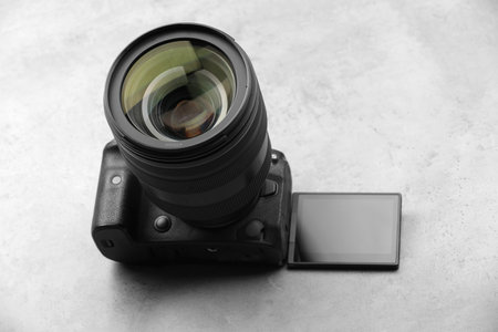 Modern photo camera on light grey tableの写真素材