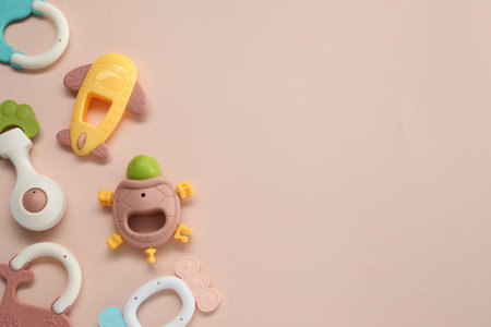 Colorful rattles on beige background, flat lay with space for text. Baby accessoriesの写真素材