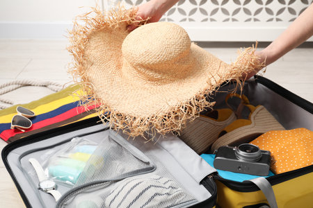 Woman packing suitcase for trip at home, closeupの写真素材
