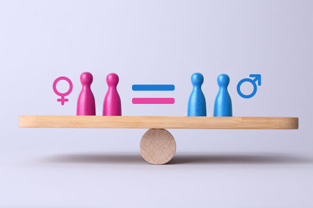 Wooden balance scales with pawns showing concept of equality between men and womenの写真素材