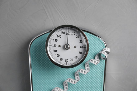 Scale and measuring tape on grey textured background, top viewの写真素材