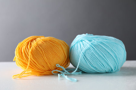 Two soft skeins of yarn on white table against gray backgroundの写真素材