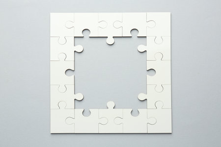 White puzzle pieces on gray background, top viewの写真素材