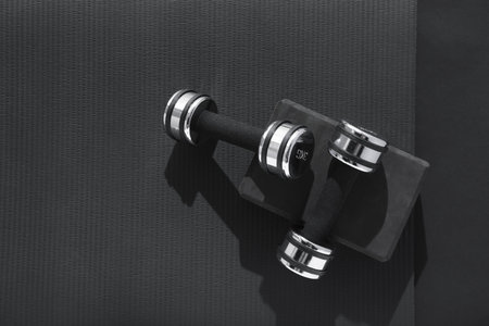 Dumbbells, yoga block and mat on black background, flat lay. Space for textの写真素材