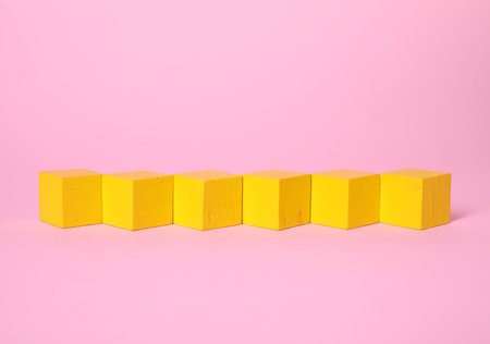 Many blank yellow cubes on pink background