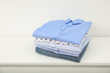 Stack of clothes on white shelf indoorsの写真素材