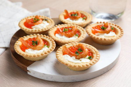 Delicious canapes with shrimps, red caviar and cream cheese on light tableの写真素材