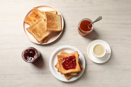 Delicious toasted bread slices served on wooden table, flat layの写真素材