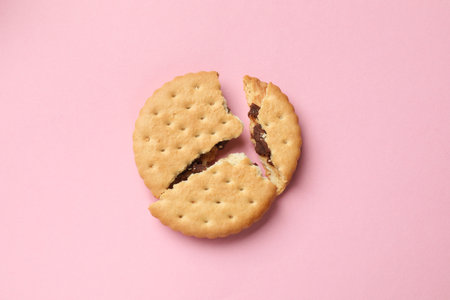 Piece of tasty sandwich cookie on pink background, top viewの写真素材