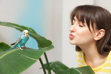 Woman with bright parrot indoors. Exotic petの写真素材