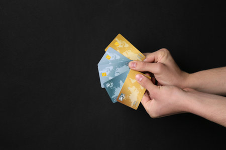 Man holding credit cards on black background, closeupの写真素材