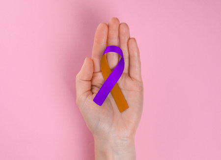 World Psoriasis Day. Woman with orange and orchid ribbon as symbol of support on pink background, top viewの写真素材