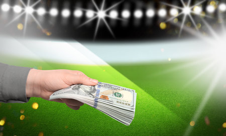 Man holding money at stadium, closeup. Space for textの写真素材