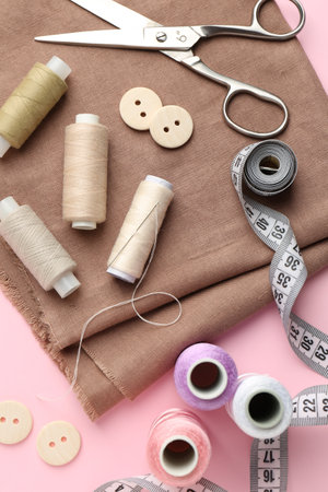 Flat lay composition with different sewing supplies on pink backgroundの写真素材