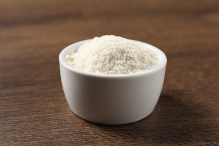 Organic coconut flour in bowl on wooden table, closeupの写真素材
