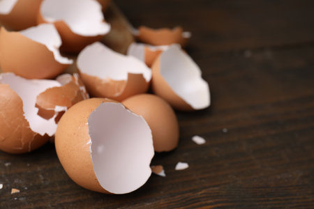 Pieces of broken eggshells on wooden table, closeup. Space for textの写真素材
