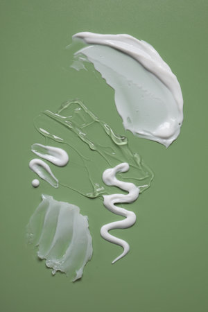 Face cream and gel on green background, top viewの写真素材