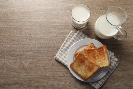 Delicious toasts with milk on wooden table, top view. Space for textの写真素材