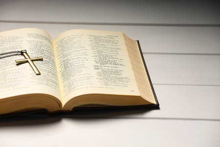 Cross with chain and Bible on white wooden table, closeup with space for text. Religion of Christianityの写真素材