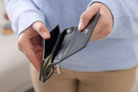 Woman with empty wallet indoors, closeup view