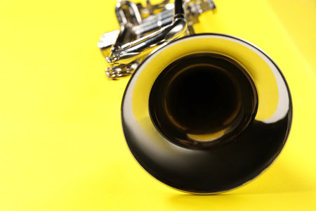 One trumpet on yellow background, closeup. Space for textの写真素材