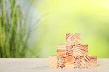 Wooden cubes on light table against blurred background. Space for textの写真素材