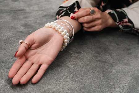Woman showing palm at gray table, closeup. Chiromancy and foretellingの写真素材