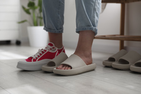 Woman changing into slippers at home, closeup