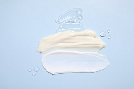 Face cream and gel on light blue background, top viewの写真素材