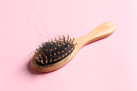 Wooden brush with lost hair on pink backgroundの写真素材