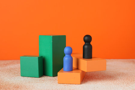 Different human figures on stands against orange background