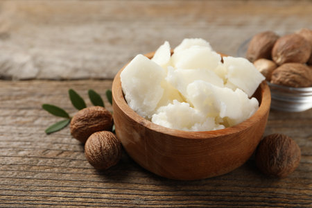 Natural shea butter and nuts on wooden table, closeupの写真素材