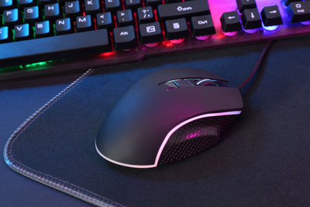 Computer mouse, mousepad and RGB keyboard on dark background, closeupの写真素材