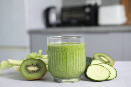 Delicious green smoothie and ingredients on light tableの写真素材