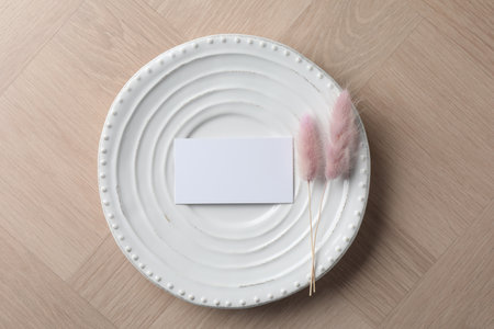Blank business cards and dried plants on wooden table, top view. Mockup for designの写真素材