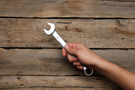 Auto mechanic with wrench at wooden table, closeupの写真素材