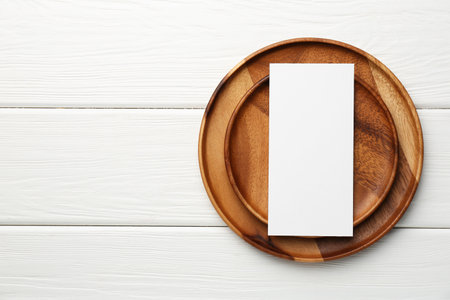 Empty menu and plates on white wooden table, top view. Mockup for designの写真素材