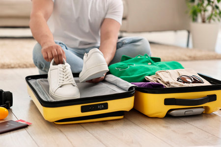 Man packing suitcase on floor at home, closeupの写真素材