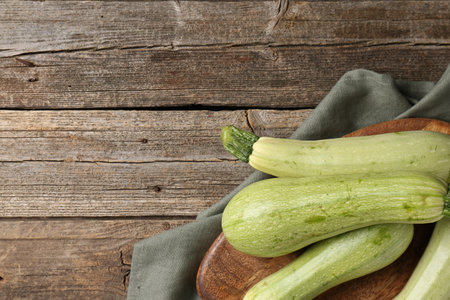 Raw green zucchinis on wooden table, top view. Space for textの写真素材