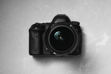 Modern photo camera on light grey marble table, top viewの写真素材