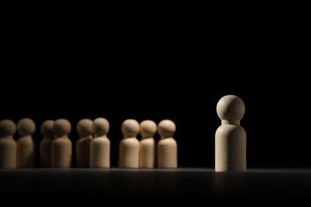 Loneliness concept. Human figure distant from others in darknessの写真素材