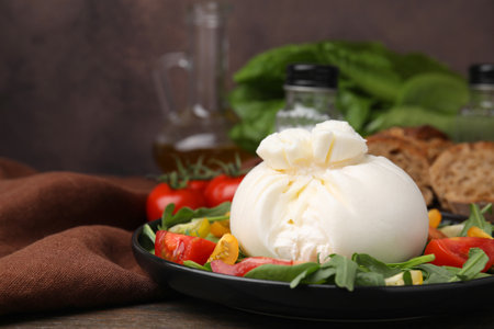 Delicious burrata salad on wooden table, closeupの写真素材
