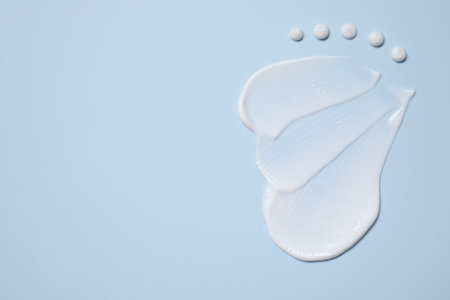 Face cream on light blue background, top view. Space for textの写真素材