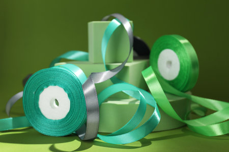 Beautiful ribbon reels and different podiums on green background, closeupの写真素材