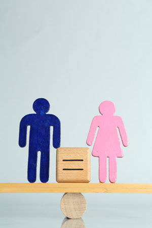 Gender equality concept. Male and female figures on scales against light backgroundの写真素材