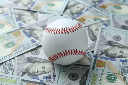 Baseball ball on many dollars bills, closeupの写真素材