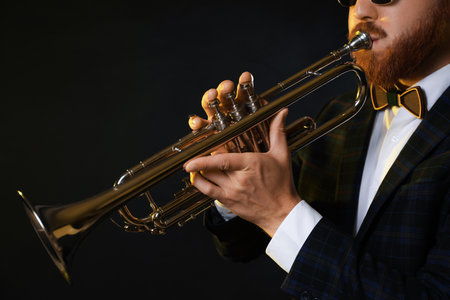 Professional musician playing trumpet on black background, closeupの写真素材