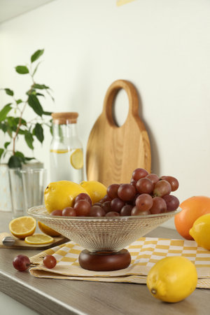 Fruit vase with grapes and lemon on wooden countertop in kitchenの写真素材