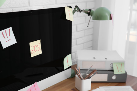 Notes with word SOS and symbols on computer at workplaceの写真素材